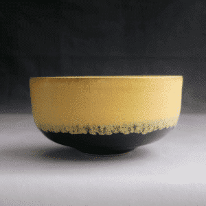Bol en grès blanc, émail jaune mat/satiné à l’intérieur et à l'extérieur sur la partie supérieure, émail noir brillant sur la partie inférieure.